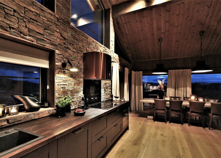 02. Kjøkken og spisestue med skiferkledd på veggen. Hytteinteriør hyttemodell Uvdal 196.